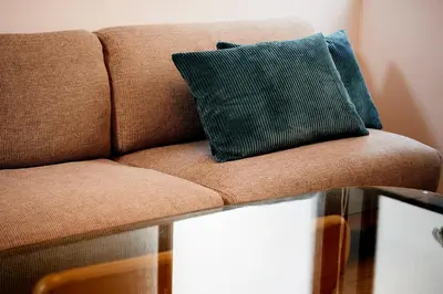 a brown couch with a green pillow on a table at 1stop to Shibuya station Japanese traditional house in Tokyo