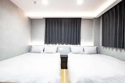 two beds in a room with white sheets at Walk to Kuramae Subway Stop YoYK in Tokyo