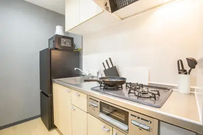 a kitchen with a stove and a black refrigerator at Walk to Kuramae Subway Stop YoYK in Tokyo