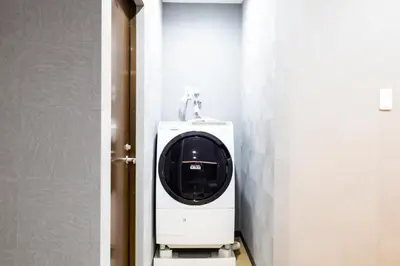 a bathroom with a washing machine in a stall at Walk to Kuramae Subway Stop YoYK in Tokyo