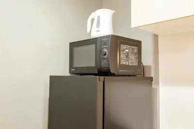 a microwave oven sitting on top of a refrigerator at Walk to Kuramae Subway Stop YoYK in Tokyo