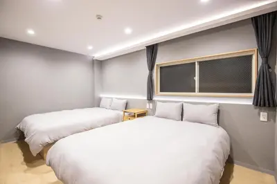 two beds in a small room with a window at Walk to Kuramae Subway Stop EoYi in Tokyo