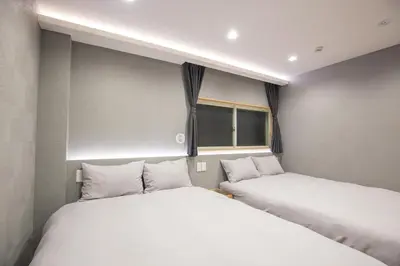 two twin beds in a room with two windows at Walk to Kuramae Subway Stop EoYi in Tokyo