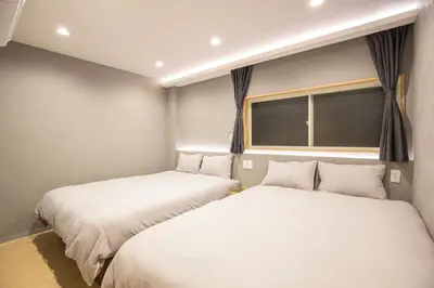 two beds sitting next to each other in a room at Walk to Kuramae Subway Stop EoYi in Tokyo
