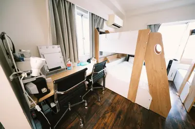 a dorm room with a desk and a bunk bed at Akasaka Central Hostel Roppongi Akasaka in Tokyo