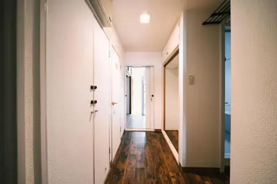 an empty hallway with white walls and wood floors at Akasaka Central Hostel Roppongi Akasaka in Tokyo