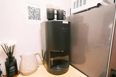 a coffee maker sitting on a counter next to a refrigerator at Akasaka Central Hostel Roppongi Akasaka in Tokyo
