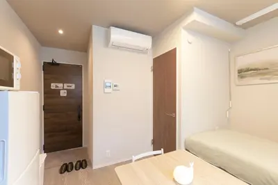 a small bedroom with a bed and a table at Fiore Kinshicho by Tranova in Tokyo