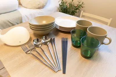 a wooden table with plates and utensils on it at Fiore Kinshicho by Tranova in Tokyo