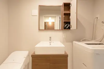 a bathroom with a sink and a washing machine at Fiore Kinshicho by Tranova in Tokyo