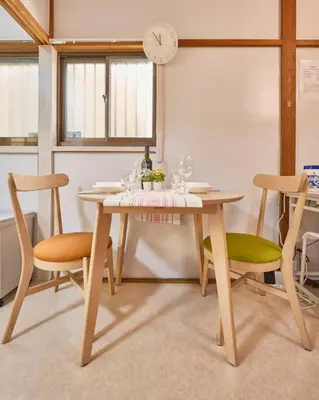 a dining room table with chairs and a clock on the wall at NEW\uff01\u8cb8\u5207\u30a2\u30d1\u30fc\u30c8\uff12DK\uff14\uff14\u33a1\u3000\u99c5\uff12\u5206\u6e0b\u8c37\u99c5\u96fb\u8eca\uff11\uff15\u5206\u3000\u30b3\u30f3\u30d3\u30cb\u516c\u5712\uff15\u79d2D\u30d9\u30c3\u30c9\uff13\u53f0\u9ad8\u901fWIFI in Tokyo