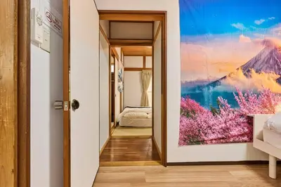a hallway with a painting on the wall at NEW\uff01\u8cb8\u5207\u30a2\u30d1\u30fc\u30c8\uff12DK\uff14\uff14\u33a1\u3000\u99c5\uff12\u5206\u6e0b\u8c37\u99c5\u96fb\u8eca\uff11\uff15\u5206\u3000\u30b3\u30f3\u30d3\u30cb\u516c\u5712\uff15\u79d2D\u30d9\u30c3\u30c9\uff13\u53f0\u9ad8\u901fWIFI in Tokyo