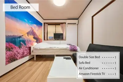 a bedroom with a bed and a tv on a wall at NEW\uff01\u8cb8\u5207\u30a2\u30d1\u30fc\u30c8\uff12DK\uff14\uff14\u33a1\u3000\u99c5\uff12\u5206\u6e0b\u8c37\u99c5\u96fb\u8eca\uff11\uff15\u5206\u3000\u30b3\u30f3\u30d3\u30cb\u516c\u5712\uff15\u79d2D\u30d9\u30c3\u30c9\uff13\u53f0\u9ad8\u901fWIFI in Tokyo