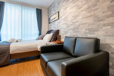 a bedroom with a bed and a leather couch at SR corpo in Tokyo