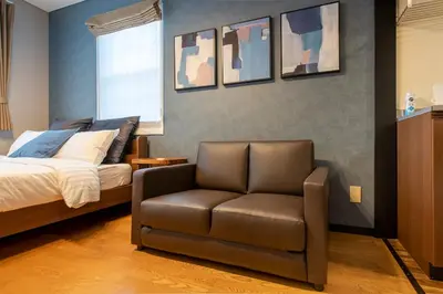 a bedroom with a bed and a leather chair at SR corpo in Tokyo