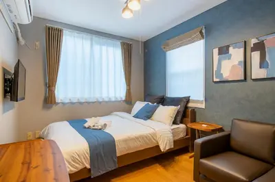 a bedroom with a bed with a cat laying on it at SR corpo in Tokyo