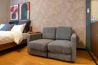 a bedroom with a couch and a chair next to a bed at SR corpo in Tokyo