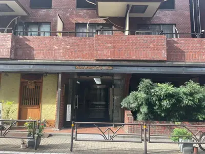 a building with a sign in front of it at \u6da9\u8c37\u9053\u7384\u5742\u72ee\u738b\u516c\u5bd3 in Tokyo