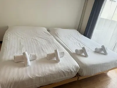 a white bed with four white pillows on it at Dainess Ichibankan Shibuya in Tokyo