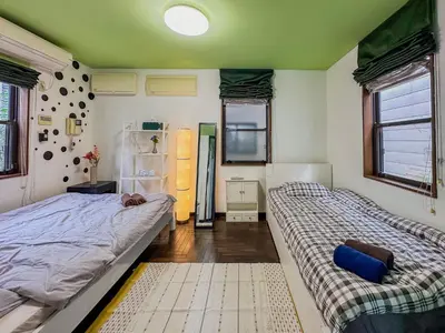 a bedroom with two beds and a refrigerator at Tranquil Tokyo Retreat #Spacious 3BR House in Hiroo in Tokyo