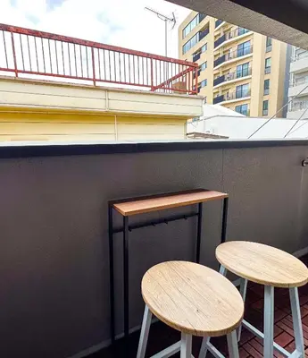 two tables and two stools on the side of a building at Tranquil Tokyo Retreat #Spacious 3BR House in Hiroo in Tokyo