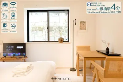 a bedroom with a bed and a table and a window at Mi-HOTEL CALM RIVERSIDE in Tokyo