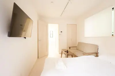 a white bedroom with a bed and a couch at Mi-HOTEL CALM RIVERSIDE in Tokyo