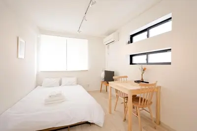 a bedroom with a bed and a desk and a table at Mi-HOTEL CALM RIVERSIDE in Tokyo
