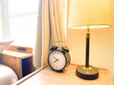 a clock sitting on a table next to a lamp at Shinkoiwa Stay, Private House, Nearby Station, Good access to Ueno&Asakusa in Tokyo