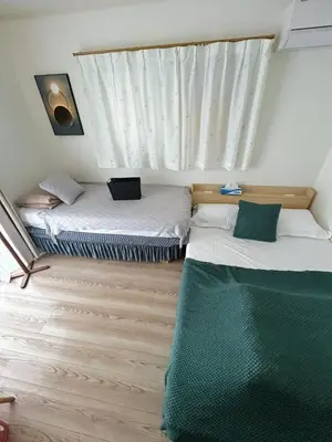 two twin beds in a room with a window at Sunflower \u6c11\u6cca in Tokyo