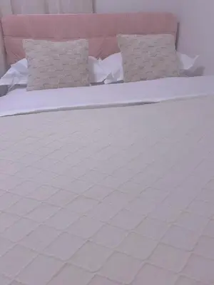 a large white bed with two pillows on it at Sunflower \u6c11\u6cca in Tokyo