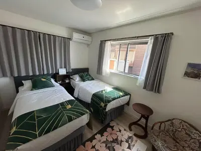 a hotel room with two beds and a window at Sunflower \u6c11\u6cca in Tokyo