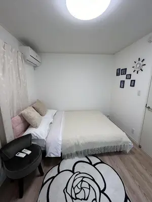 a small bedroom with a bed and a chair at Sunflower \u6c11\u6cca in Tokyo