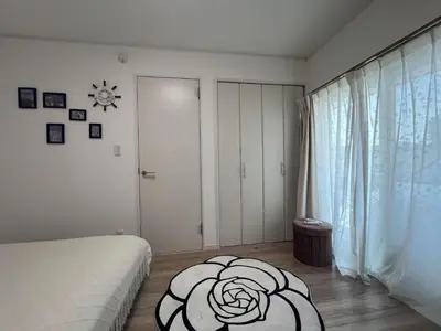 a white room with a bed and a window at Sunflower \u6c11\u6cca in Tokyo