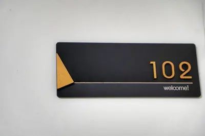 a black and gold sign on a wall at Sunflower \u6c11\u6cca in Tokyo