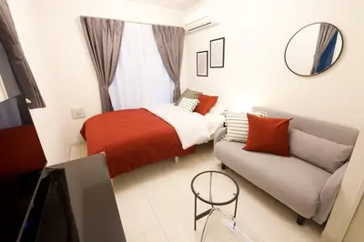 a small bedroom with a bed and a couch at \u30bb\u30f3\u30c8\u30ec\u30a4\u62bc\u4e0a\u30ce\u30fc\u30b9 205 in Tokyo
