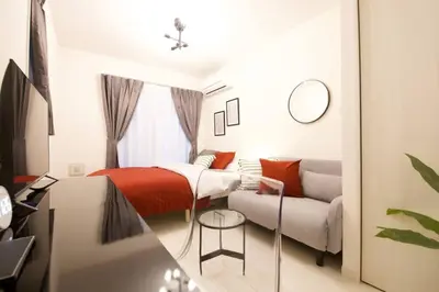 a small bedroom with a bed and a couch at \u30bb\u30f3\u30c8\u30ec\u30a4\u62bc\u4e0a\u30ce\u30fc\u30b9 205 in Tokyo