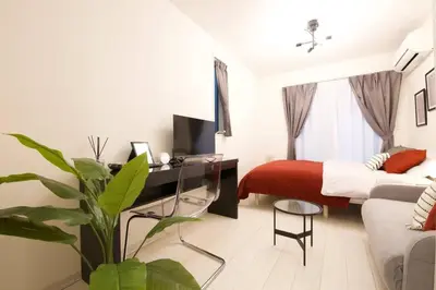 a bedroom with a bed and a desk and a plant at \u30bb\u30f3\u30c8\u30ec\u30a4\u62bc\u4e0a\u30ce\u30fc\u30b9 205 in Tokyo