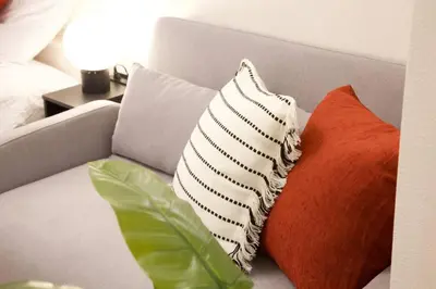 two pillows sitting on a couch in a bedroom at \u30bb\u30f3\u30c8\u30ec\u30a4\u62bc\u4e0a\u30ce\u30fc\u30b9 205 in Tokyo