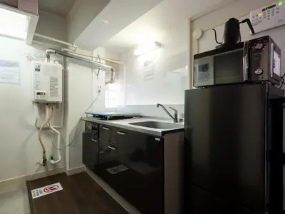 a kitchen with a black refrigerator and a sink at Hatagaya heim 403 in Tokyo