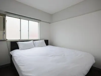 a white bed in a room with two windows at Hatagaya heim 403 in Tokyo