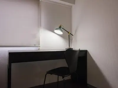 a desk with a lamp and a chair in a room at Hatagaya heim 403 in Tokyo