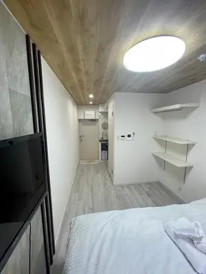 a bedroom with a bed and a television in a room at fukuhana\u6771\u65b0\u5bbf in Tokyo