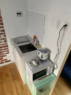 a small kitchen with a stove and a microwave at The Standard Apartment SHIBUYA SASAZUKA Room K in Tokyo