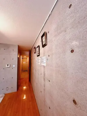 a hallway with a wall with pictures on it at Shirokane Apartment Hotel 2 in Tokyo