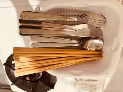 a basket filled with pasta and utensils in a sink at Shirokane Apartment Hotel 2 in Tokyo