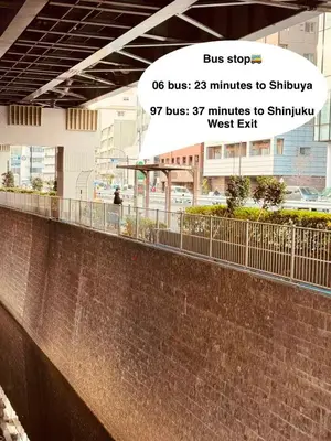 a sign for a bus stop on a brick wall at Shirokane Apartment Hotel 2 in Tokyo