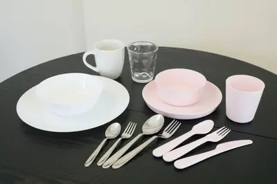 a black table with white plates and silverware on it at \u30b5\u30f3\u30cf\u30a4\u30c4\u521d\u53f0 201 in Tokyo
