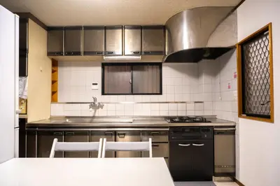 a kitchen with stainless steel appliances and a table at Miyabi Inn-Kameido in Tokyo
