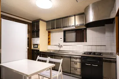 a kitchen with a table and a white table and chairs at Miyabi Inn-Kameido in Tokyo